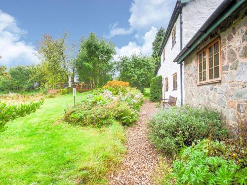 a stone house with a garden in front of it at Vintage Holiday home in Welshpool with Garden in Welshpool