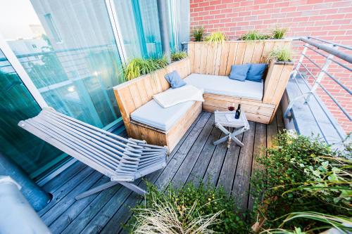 Balcón con sofá, silla y mesa en fjord hotel berlin en Berlín