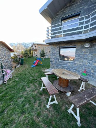 a picnic table and two benches in a yard at Villa 80 Kodra e Diellit in Tetovo