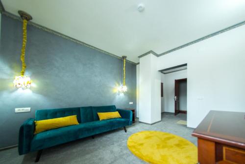 a living room with a blue couch and yellow pillows at Voila Inn Predeal in Predeal