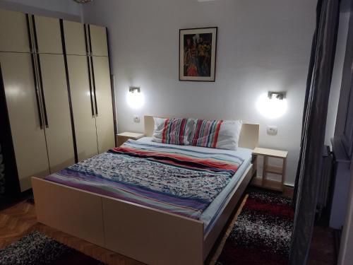a bed in a bedroom with two lights on at Zozi urban studio in Skopje