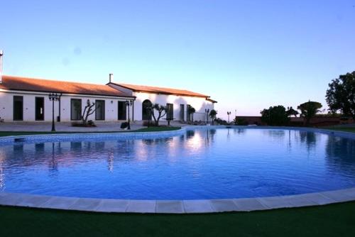 a large swimming pool in front of a building at Agriturismo Monticelli in Mussomeli