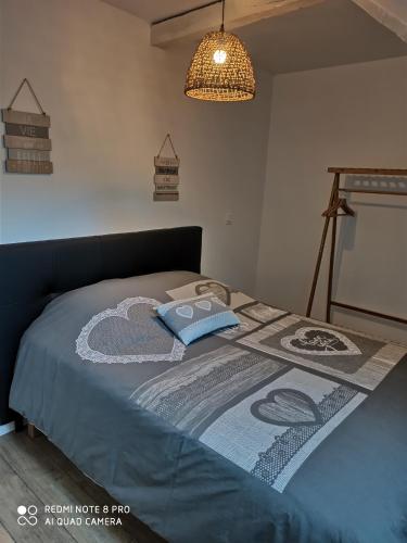 un lit avec une couette dessus dans une chambre dans l'établissement Triplex 110 m2 centre historique avec jacuzzi DINAN, à Dinan