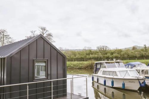 a boat is docked next to a building at Water Cabin With Water Sports Equipment and Bikes, Bath in Bristol
