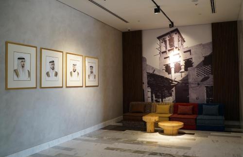 a room with a couch and pictures on the wall at Movenpick Jumeirah Village Triangle in Dubai