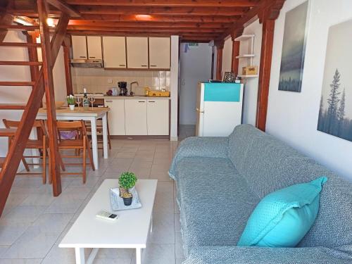 a living room with a blue couch and a kitchen at Panorama Apartments in Asos
