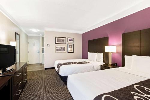a hotel room with two beds and a flat screen tv at La Quinta by Wyndham Boston-Andover in Andover