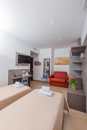 a hotel room with two beds and a red couch at Hotel Repubblica in Milan