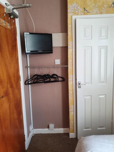 een kamer met een tv en een kast met een deur bij The Rutlands in Blackpool