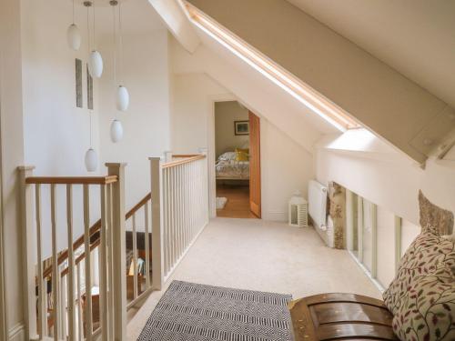 a attic room with a staircase and a bed at Higher Weddicott Barn in Newton Abbot