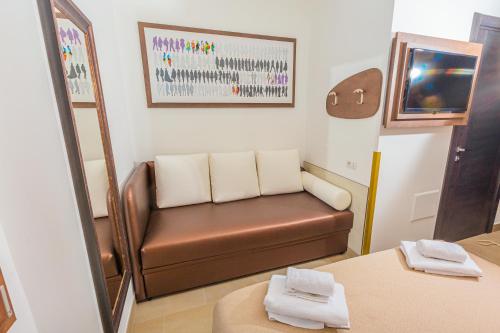 una sala de espera con un sofá de cuero marrón y un espejo en Hotel Repubblica en Milán