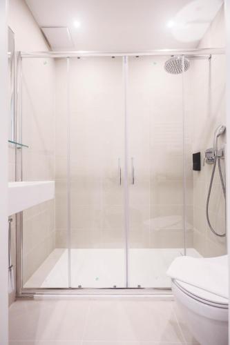 クレムス・アン・デア・ドナウにあるPARKHOTEL Kremsのトイレ付きのバスルームのガラス製シャワー
