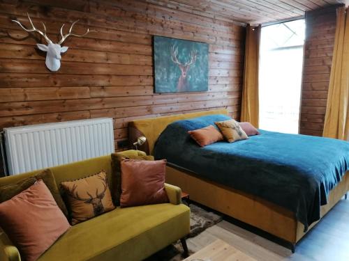 una camera con letto e divano di Maison d'hôte Les Notes Endormie Suite Le Refuge a Walcourt