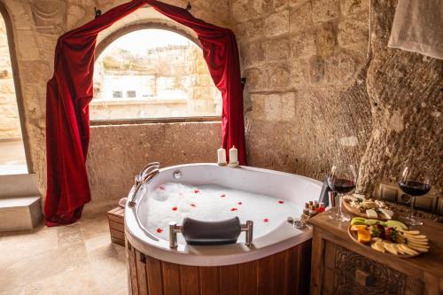a bath tub in a room with a window at Kayata Cave Suites Special Class in Urgup
