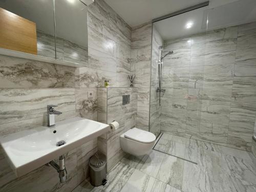 uma casa de banho branca com um lavatório e um WC em Rannakivi Riverside apartments em Pärnu