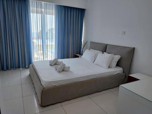 a bedroom with a large bed with two pillows on it at Ocean Suites Luxury Apartments in Protaras