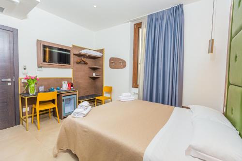 a bedroom with a bed and a desk with a computer at Hotel Repubblica in Milan