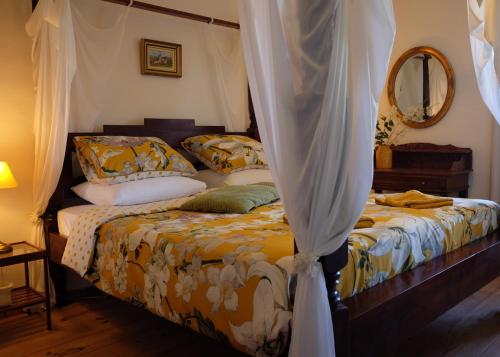 ein Schlafzimmer mit einem Himmelbett in der Unterkunft La Bastide Portoly Gîte "Le Pigeonnier" in Penne-dʼAgenais