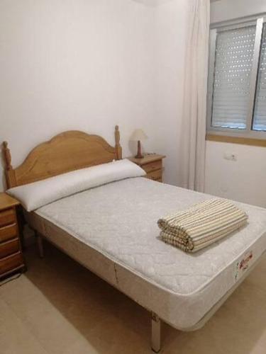 Schlafzimmer mit einem Bett und einem Fenster in der Unterkunft Piso en Raxó in Raxo