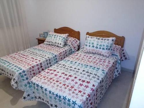 2 Betten nebeneinander in einem Zimmer in der Unterkunft Piso en Raxó in Raxo