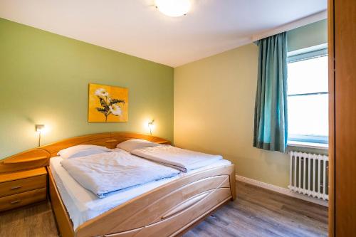 - une chambre avec un lit et une fenêtre dans l'établissement Haus Am Anker Wohnung 4, à Büsum