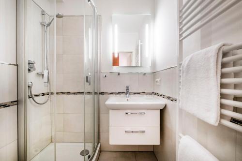 La salle de bains est pourvue d'un lavabo et d'une douche. dans l'établissement Haus Am Anker Wohnung 4, à Büsum