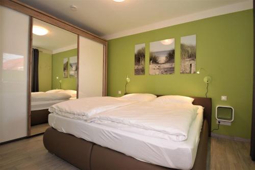 um quarto com uma cama grande e um espelho em Haus Deichkieker Apartment 1 6 Deichschaf em Büsum