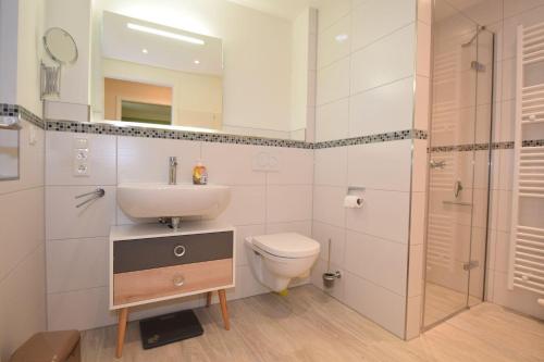 uma casa de banho com um lavatório, um WC e um chuveiro em Haus Deichkieker Apartment 1 6 Deichschaf em Büsum