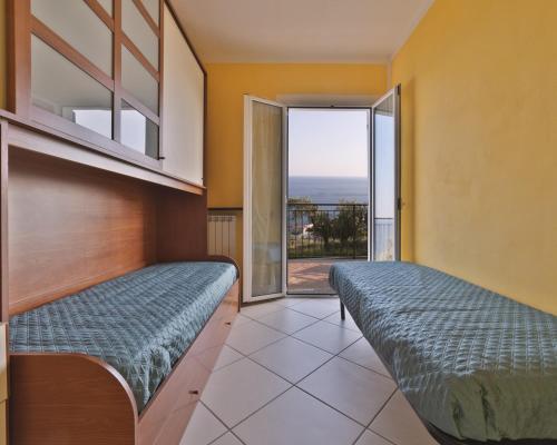deux lits dans une chambre avec vue sur l'océan dans l'établissement Casa Conca Azzurra, à Costarainera