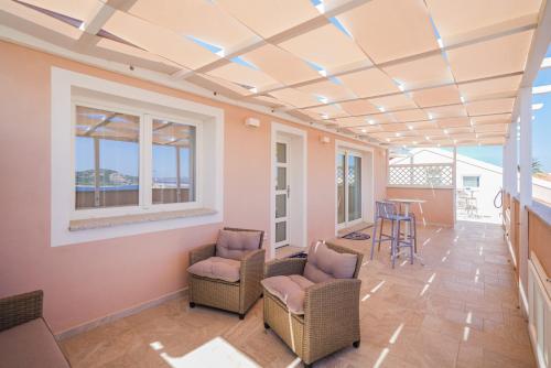 a room with chairs and a table and windows at Controvento in La Maddalena