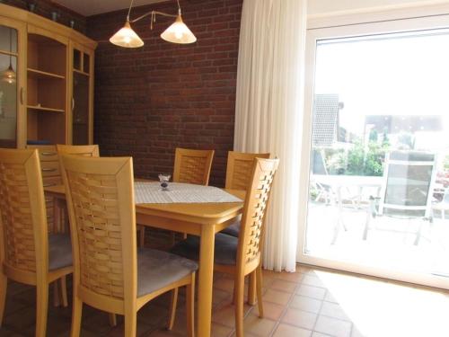 a dining room with a table and chairs and a window at "LüttMeerDeern", Im Grünen Winkel 10 - Wohnung im Erdgeschoss in Kellenhusen
