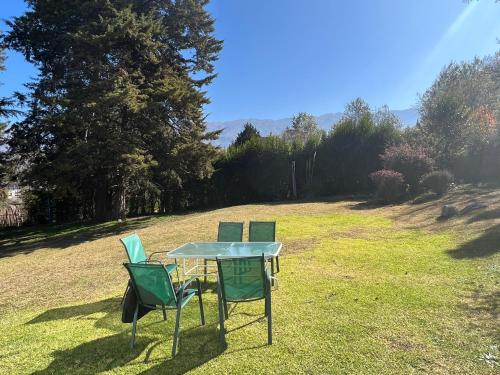 two chairs and a table in a field at Casa divina temporaria en Tafí Del Valle ,pleno centro in Tafí del Valle