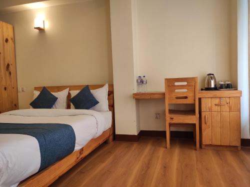 a bedroom with a bed and a table and a desk at Awale House in Pātan