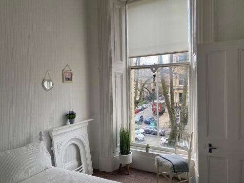 um quarto com uma cama e uma grande janela em Captivating apartment in glasgow westend uk em Glasgow