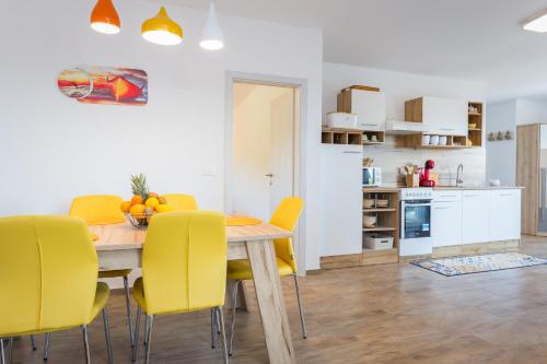 kuchnia i jadalnia ze stołem i żółtymi krzesłami w obiekcie Sunny Sunny Peroj w mieście Vodnjan
