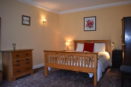 una camera con letto, cassettiera in legno e letto sidx sidx sidx. di West End Apartment a Edimburgo