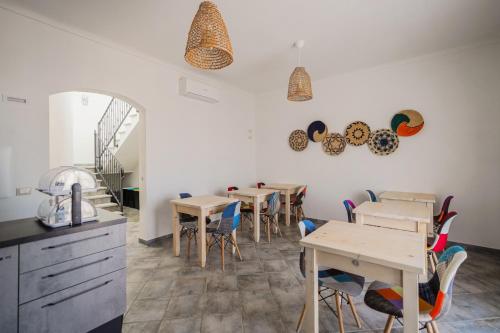 a dining room with tables and chairs and a staircase at Controvento in La Maddalena