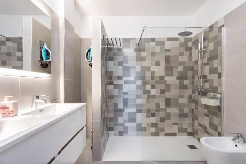 a bathroom with a shower and a toilet and a sink at Home2Book Design Sea Views Caletillas, Pool in Candelaria