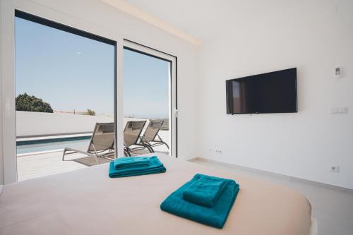a bedroom with a bed with blue towels on it at Villa Sofia Atlantica in Lourinhã