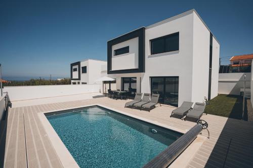 a house with a swimming pool in front of it at Villa Sofia Atlantica in Lourinhã