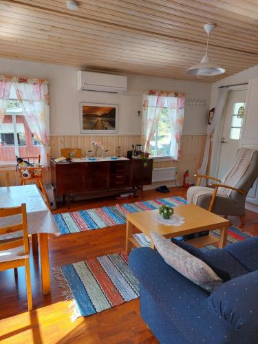 a living room with a couch and a table at Ilmastoitu kesämökki Askolassa lähellä Porvoota in Askola