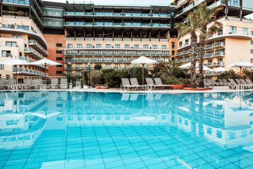 a large swimming pool in front of a building at Holiday Inn Express - Malta, an IHG Hotel in St Julian's