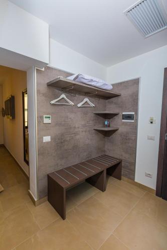 a bench in a room with a wall with shelves at Hotel Repubblica in Milan