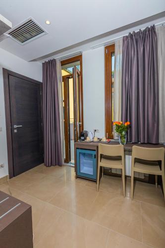 a living room with a table and chairs and purple curtains at Hotel Repubblica in Milan