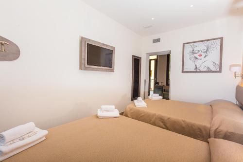 a room with two beds and a flat screen tv at Hotel Repubblica in Milan