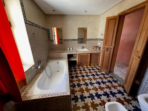 baño grande con bañera y lavamanos en Les Ailes du sourire en Esauira