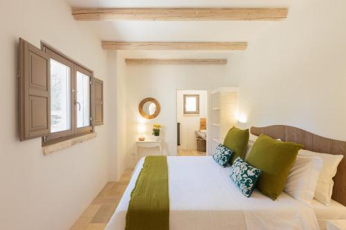 a bedroom with a large bed with green pillows at Lamia del Bosco con Piscina in Ostuni