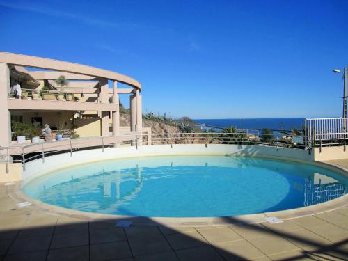 une grande piscine devant un immeuble dans l'établissement appartement 1 chambre vue dominante mer, à Sète