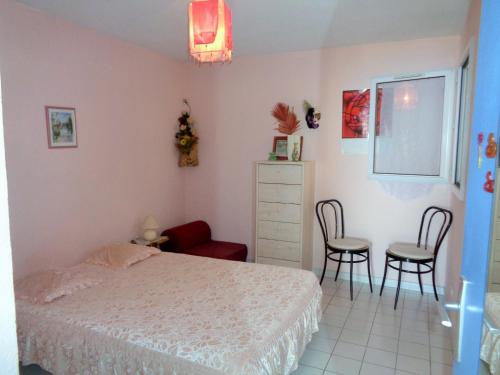 une chambre avec un lit, une table et des chaises dans l'établissement appartement 1 chambre vue dominante mer, à Sète