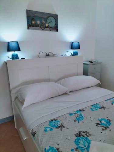 a bed with a white headboard in a bedroom at I 23 PASSI GAETA in Gaeta
